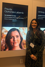 Pravda Quinones-Labernik of the Abel and Ferri Labs standing in front of the banner announcing her HHMI Gilliam Fellowship